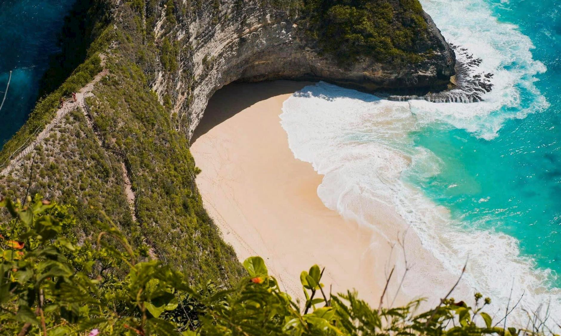 Kelingking Beach na Bali z turkusowym morzem i stromymi, zielonymi klifami