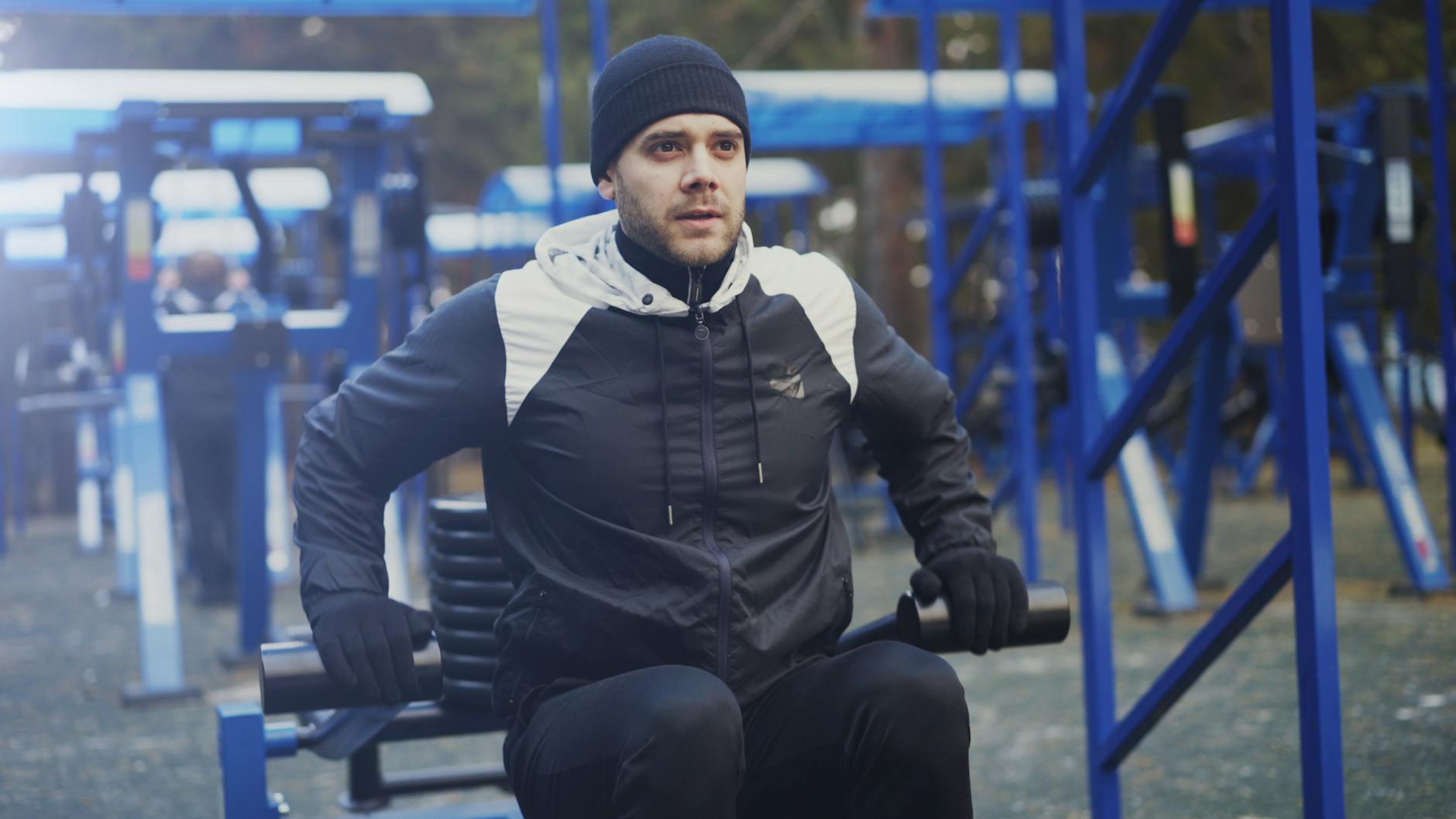 Mężczyzna ćwiczący na siłowni plenerowej w zimowej odzieży