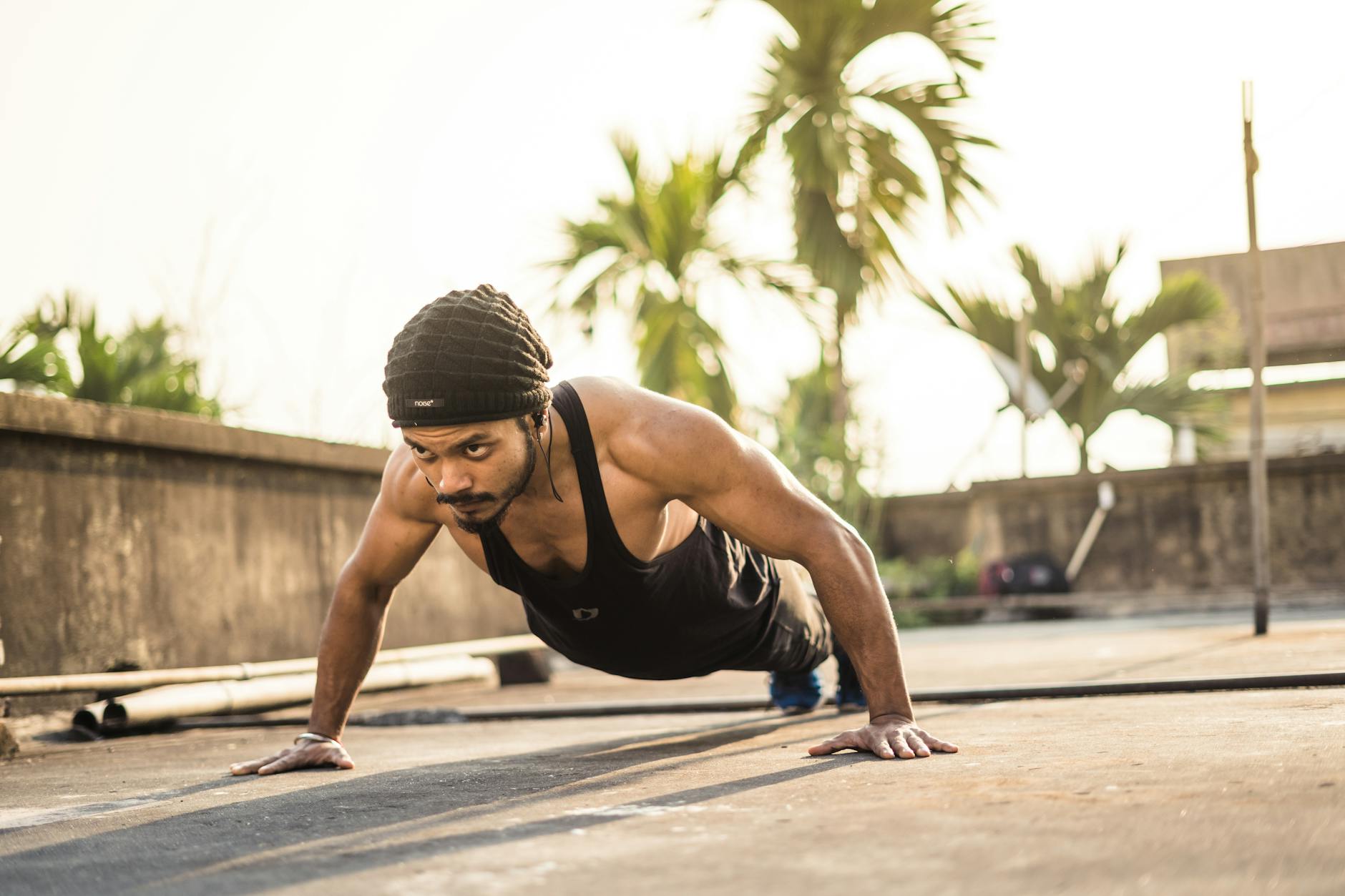 Mężczyzna robi pompki na dachu o wschodzie słońca