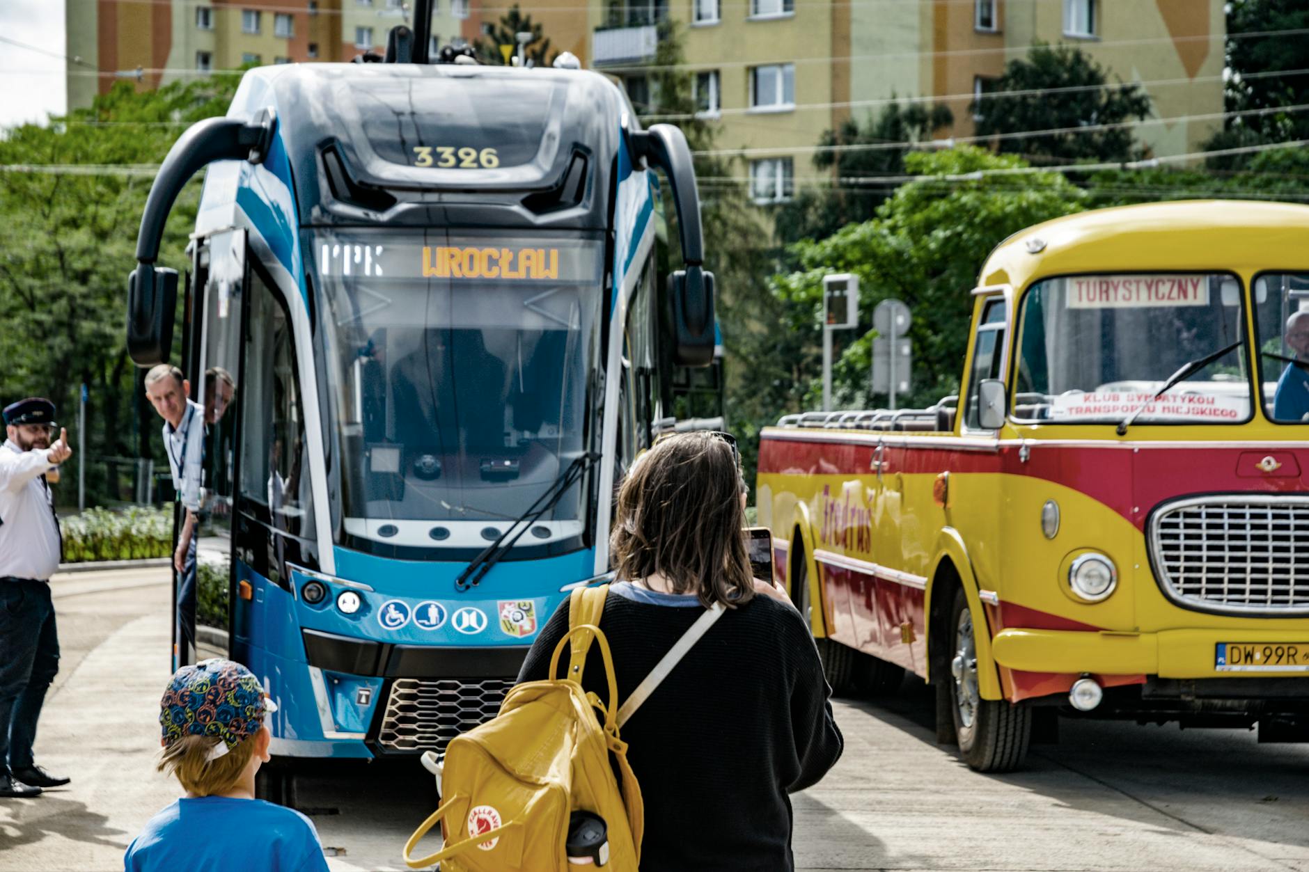 Nowoczesny tramwaj i zabytkowy autobus na ulicy we Wrocławiu