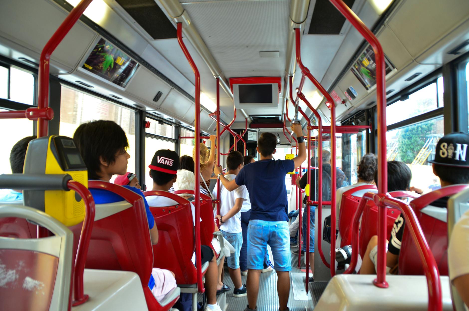 Pasażerowie siedzący i stojący w miejskim autobusie w Rzymie