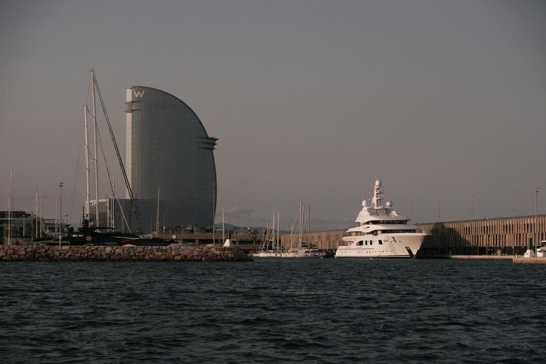 Zachód słońca nad Port Vell w Barcelonie z hotelem W i luksusowymi jachtami