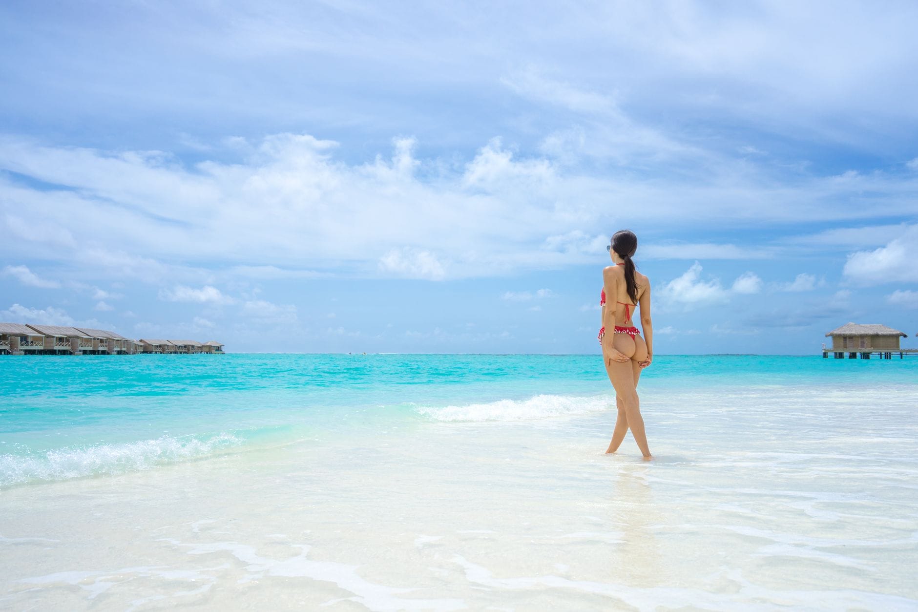 Kobieta w bikini odpoczywa na tropikalnej plaży z turkusowym morzem