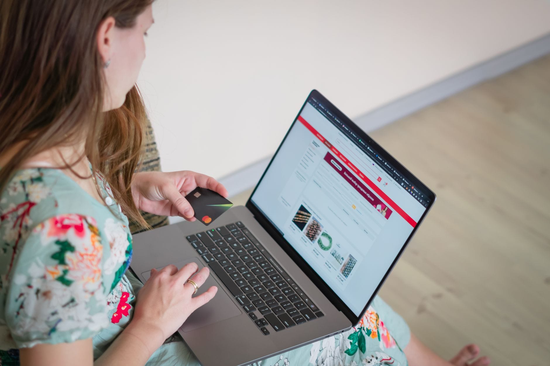 Kobieta w kwiecistej sukience rezerwuje wakacje online kartą kredytową
