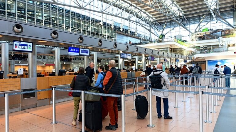 Podróżni przy stanowiskach odprawy na lotnisku w Hamburgu