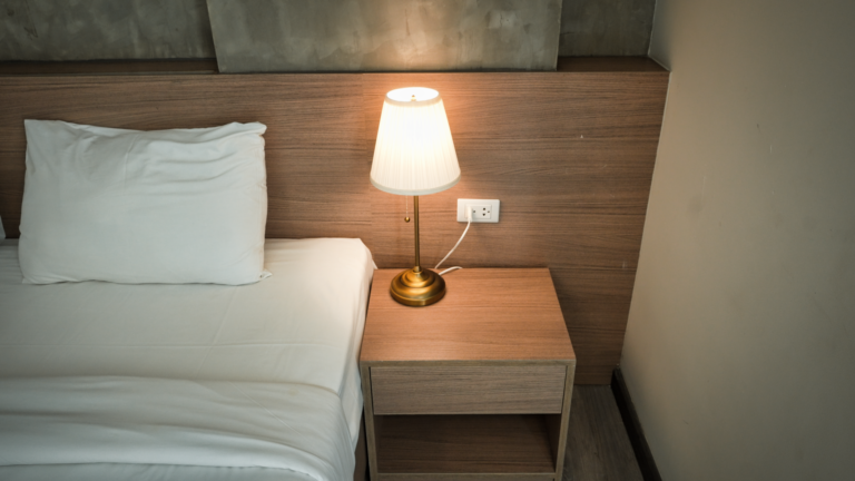Elegancka sypialnia z lampą na drewnianej szafce nocnej
