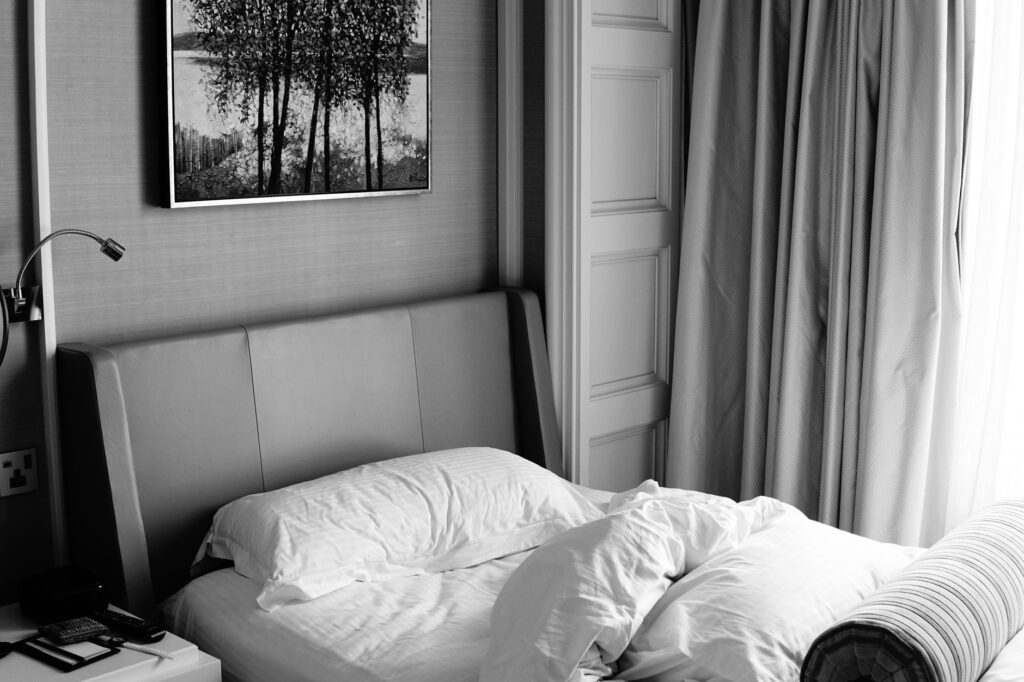 Stylowa sypialnia z łóżkiem i monochromatyczną dekoracją ścienną